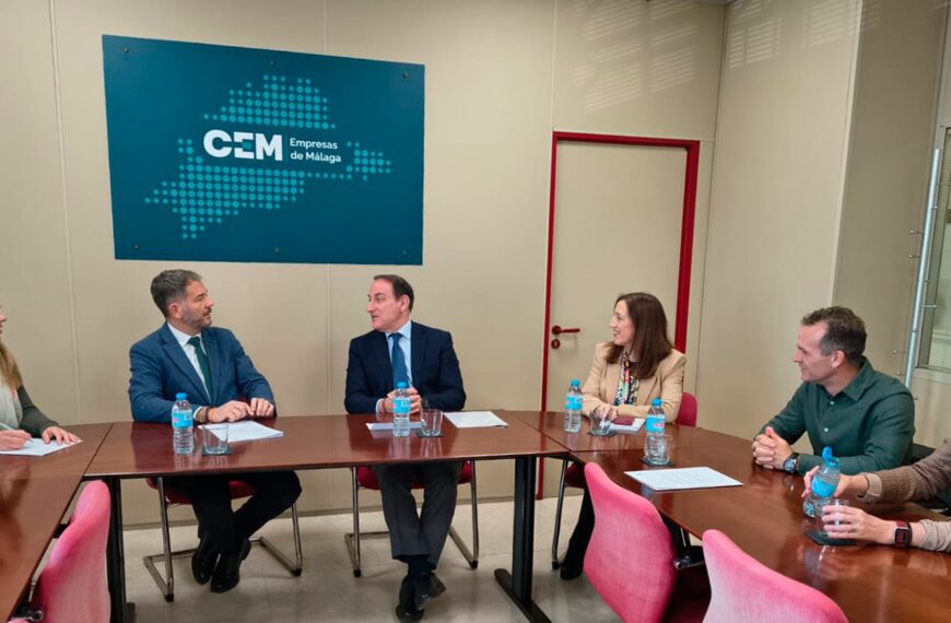 Reunión de trabajo en la sede de la Confederación de Empresarios de Málaga. Seis personas dialogan sentadas a una mesa de juntas con el logotipo de la organización al fondo